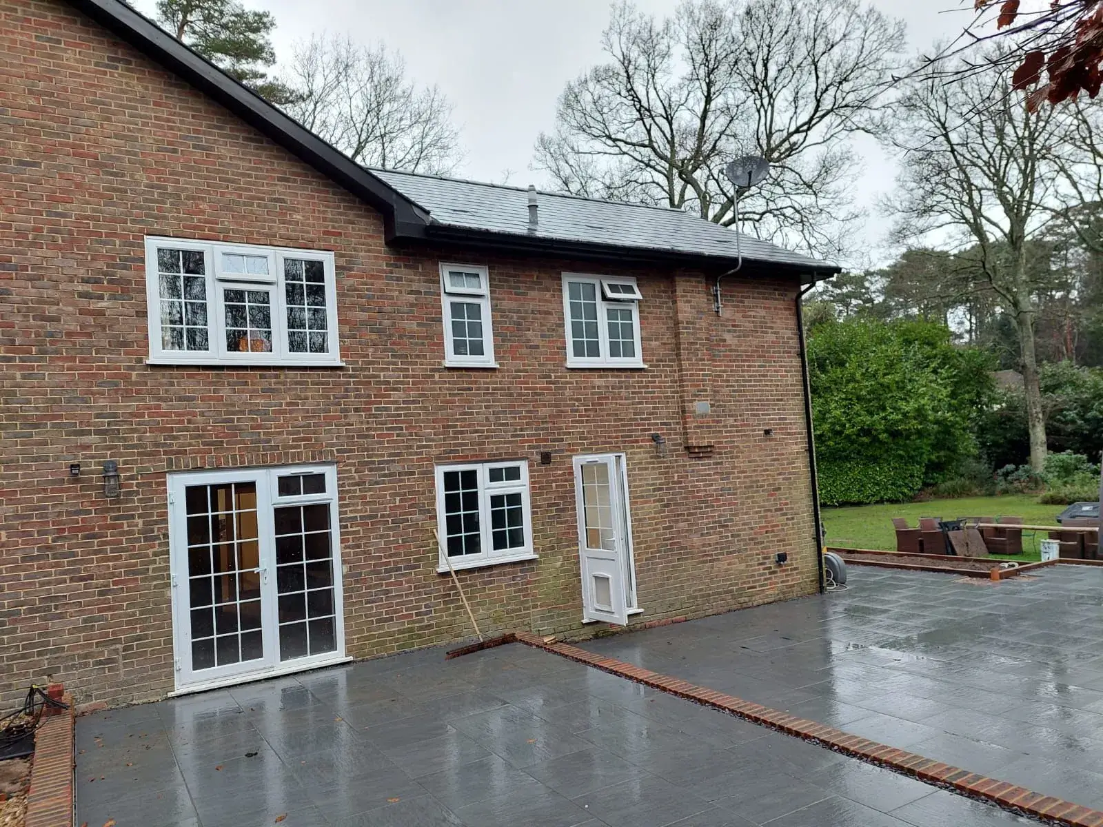 A brick house with white windows and white doors.